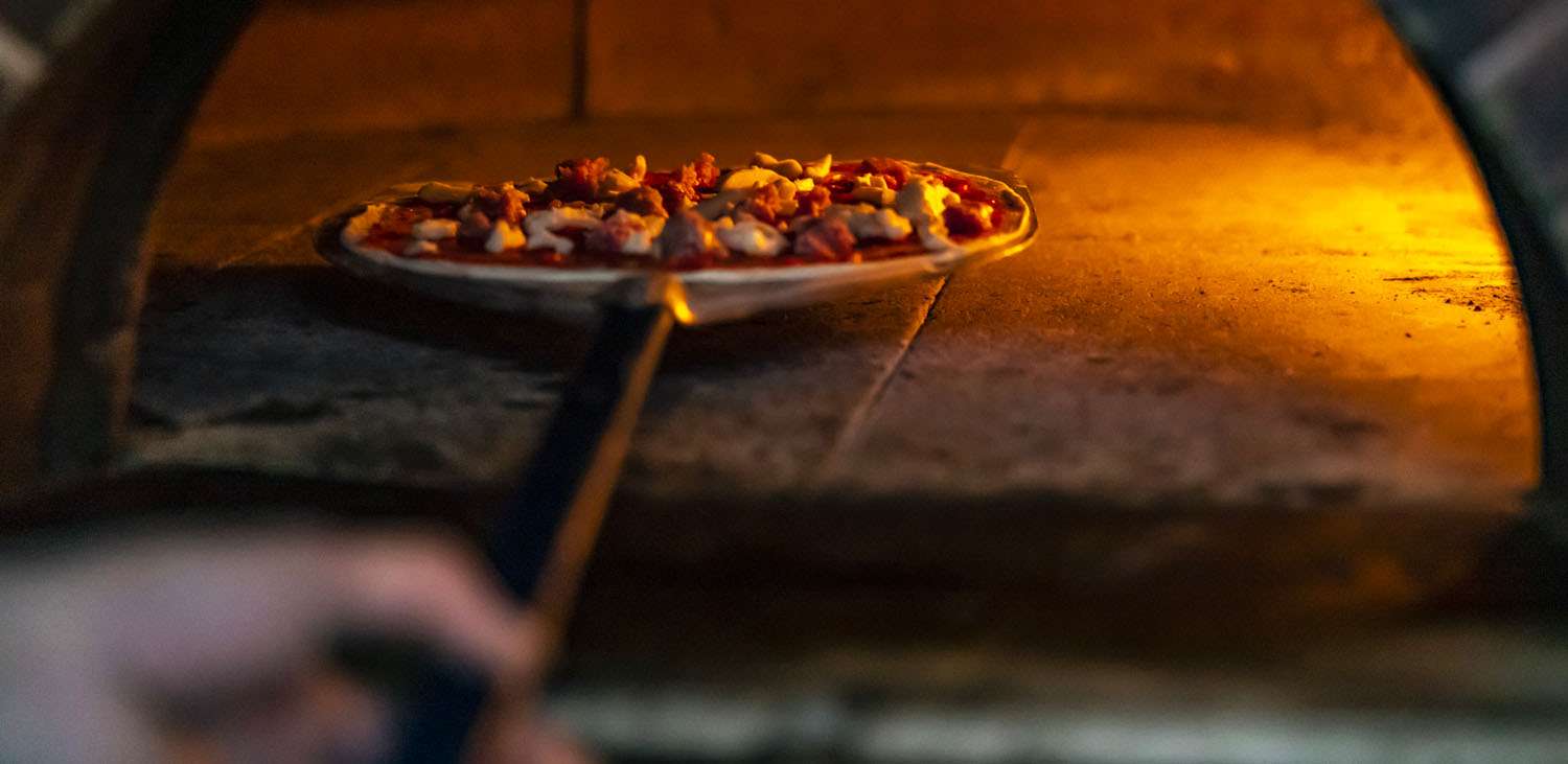 putting pizza in the oven